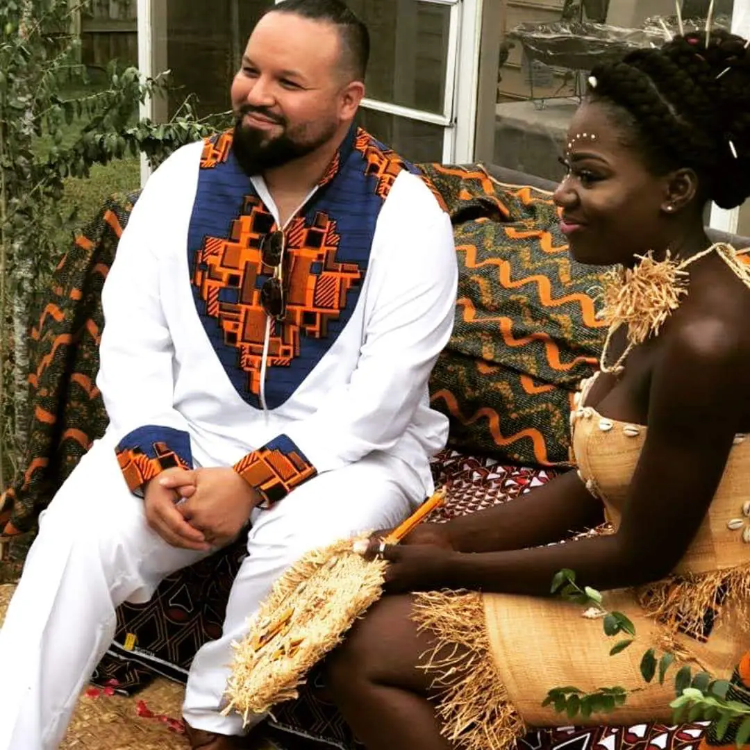 Marcelle and Miguel seated together in traditional Gabonese attire during their traditional celebration