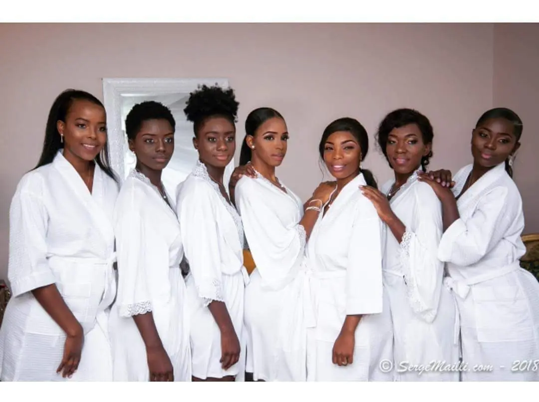 The bride and her bridal party in matching white robes preparing for the ceremony